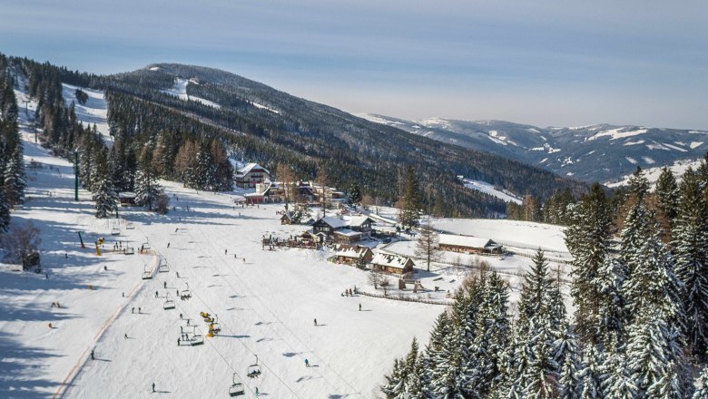 Erlebnisalm Mönichkirchen, © schischaukel-moenichkirchen-mariensee-gmbh-fueloep Winterlandschaft mit Skilift und verschneiten Bergen in Mönichkirchen.