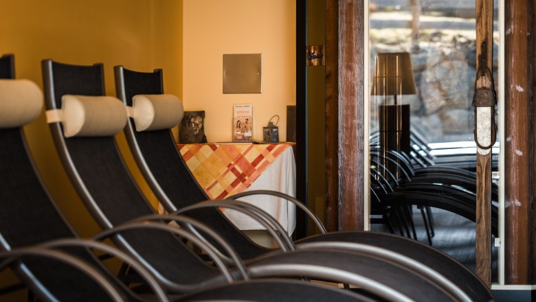 Sonnenhof, © Wiener Alpen/Christian Kremsl Innenansicht eines Ruheraums mit Liegestühlen und einem Tisch mit Tischdecke.