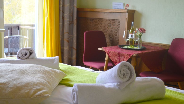 Doppelzimmer, © Gästehaus 3Länderblick / Anna Müllner Doppelzimmer mit Bett, Tisch, Stühlen und Balkon.
