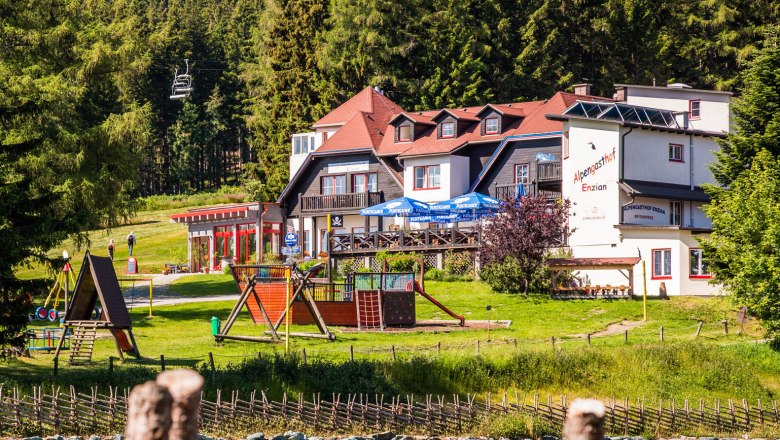 Alpengasthof Enzian, © Alpengasthof Enzian, Foto Franz Zwickl Alpengasthof Enzian mit Spielplatz und Wald im Hintergrund.