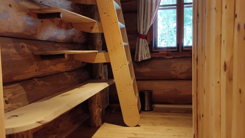 Room entrance, © 2021 Maxsam GmbH Wooden interior with ladder and window in one room.