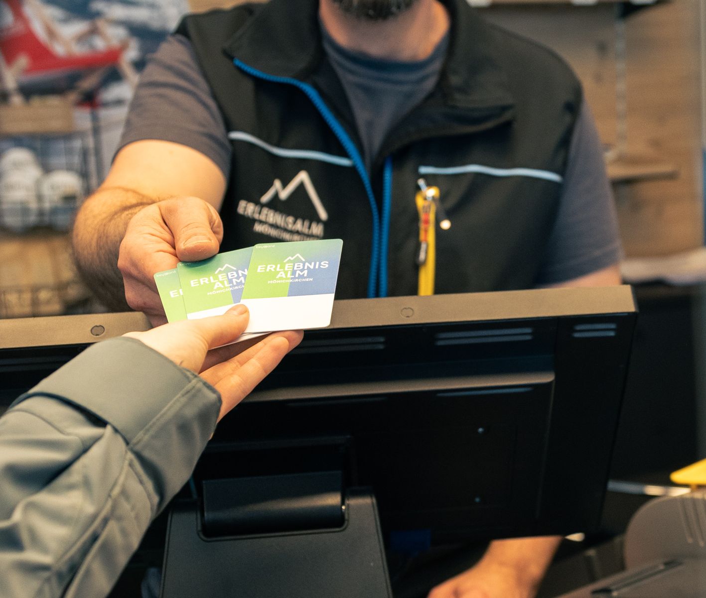 Ein Ticket wird von einer Mitarbeiterin oder einem Mitarbeiter an einen Gast übergeben. Die Übergabe findet im Eingangs- oder Kassenbereich statt.