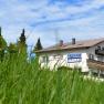 Gasthaus 3-L&auml;nderblick behind a meadow with trees in the background.