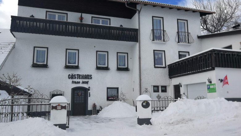 Winterliche Ansicht eines G&auml;stehauses mit Schnee bedeckt.