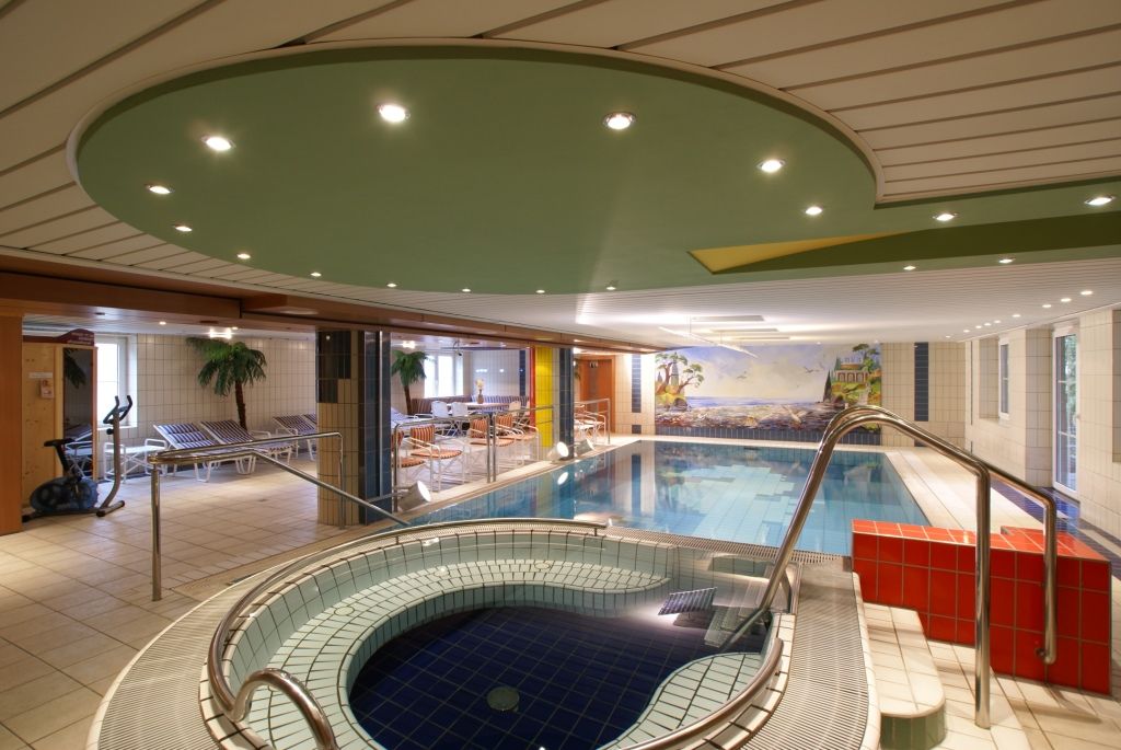 Innenpoolbereich mit Whirlpool und Liegestühlen im Hotel Thier.