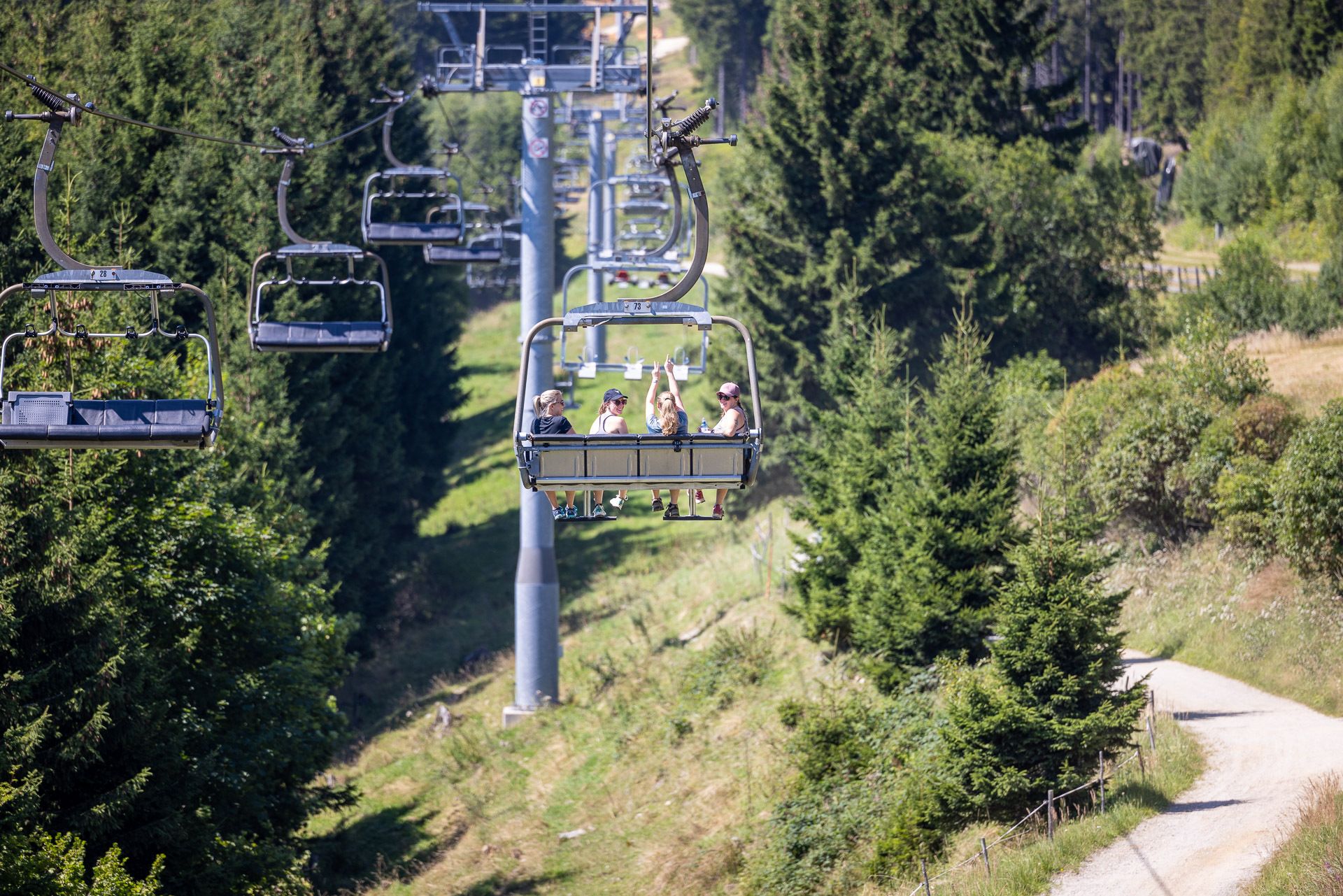Vier Freundinnen fahren mit dem Sessellift auf den Berg