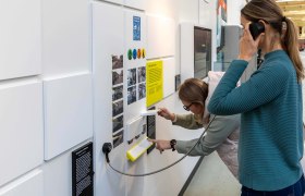 Zwei Frauen interagieren mit einer Ausstellung im Verkehrsmuseum der Wiener Linien.