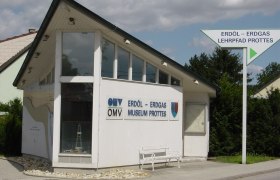 Geb&auml;ude des Erd&ouml;l-Erdgas Museums Prottes mit Wegweiser.