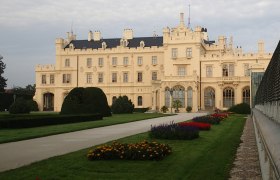 Schloss Lednice mit gepflegten G&auml;rten im Vordergrund.