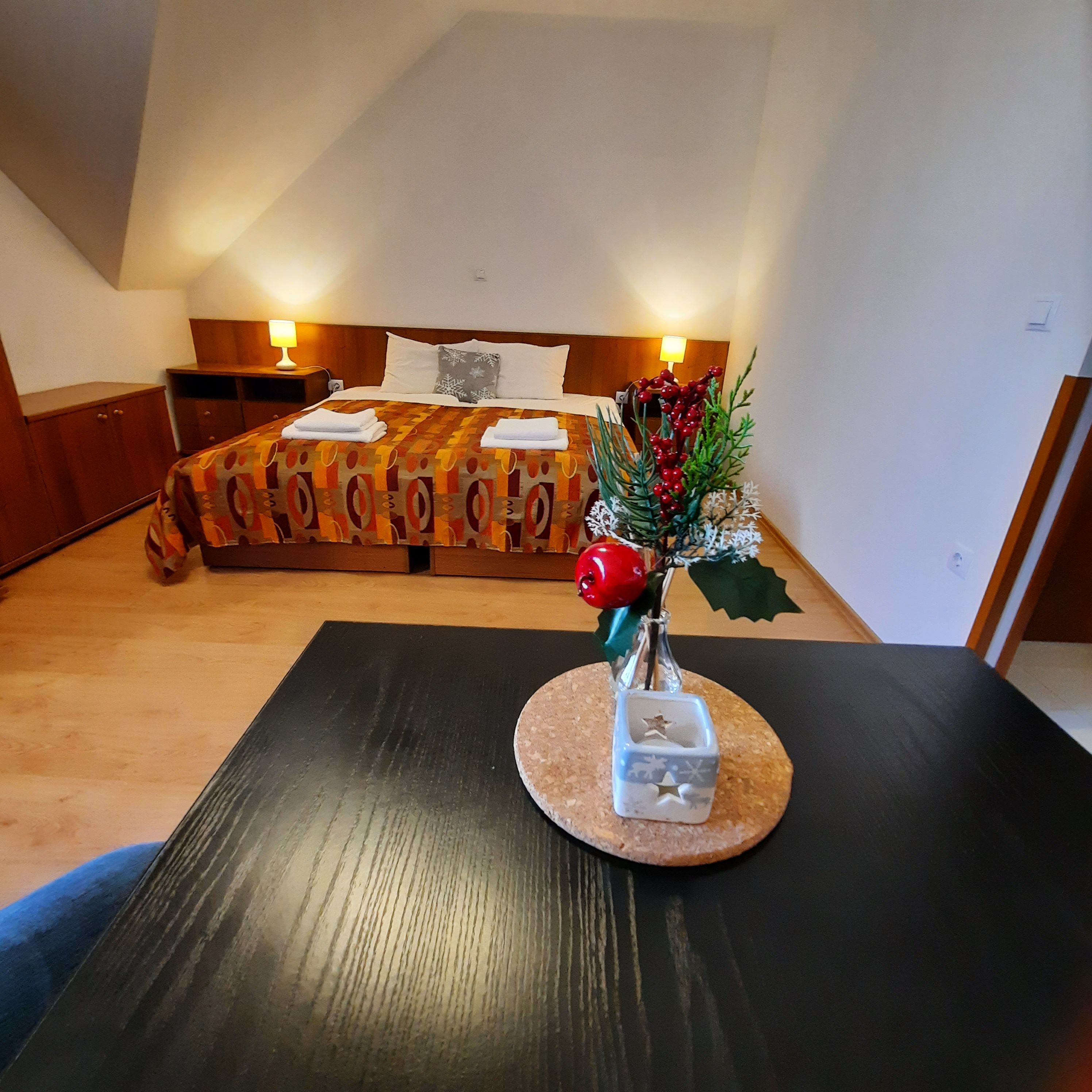 Ein gemütliches Doppelzimmer mit einem dekorierten Tisch im Vordergrund und einem Bett im Hintergrund.