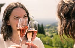 Zwei Freundinnen stoßen mit einem Glas Sekt an