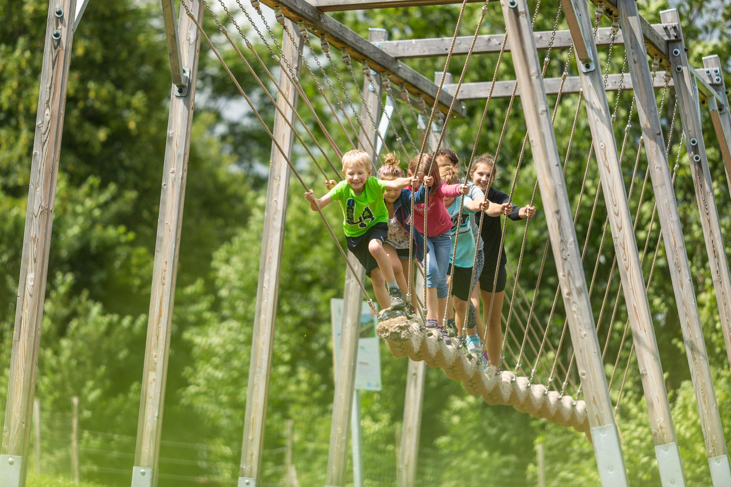 Kinder auf einer Hängebrücke im Motorikpark St. Corona.