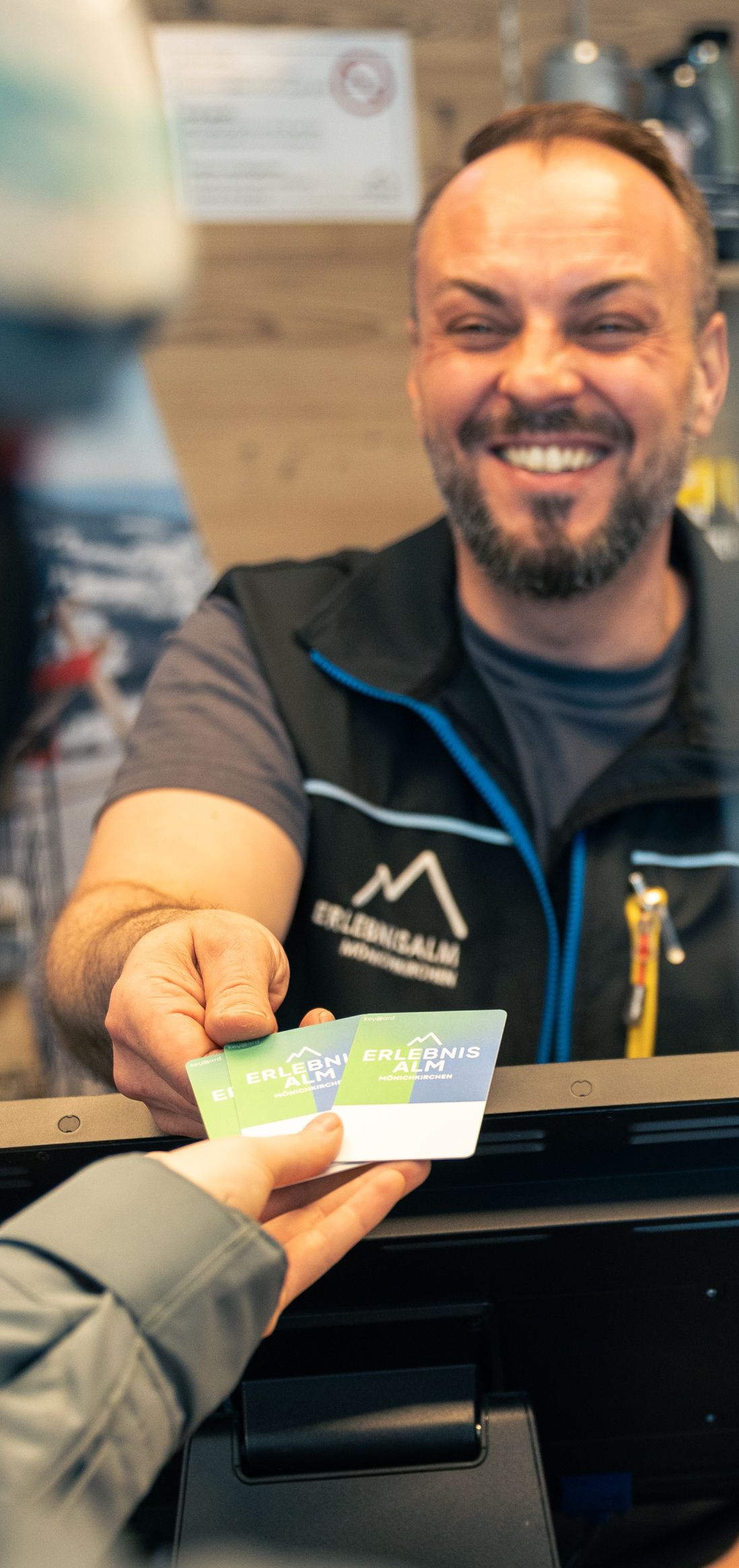 Ein Ticket wird von einer Mitarbeiterin oder einem Mitarbeiter an einen Gast übergeben. Die Übergabe findet im Kassenbereich statt.