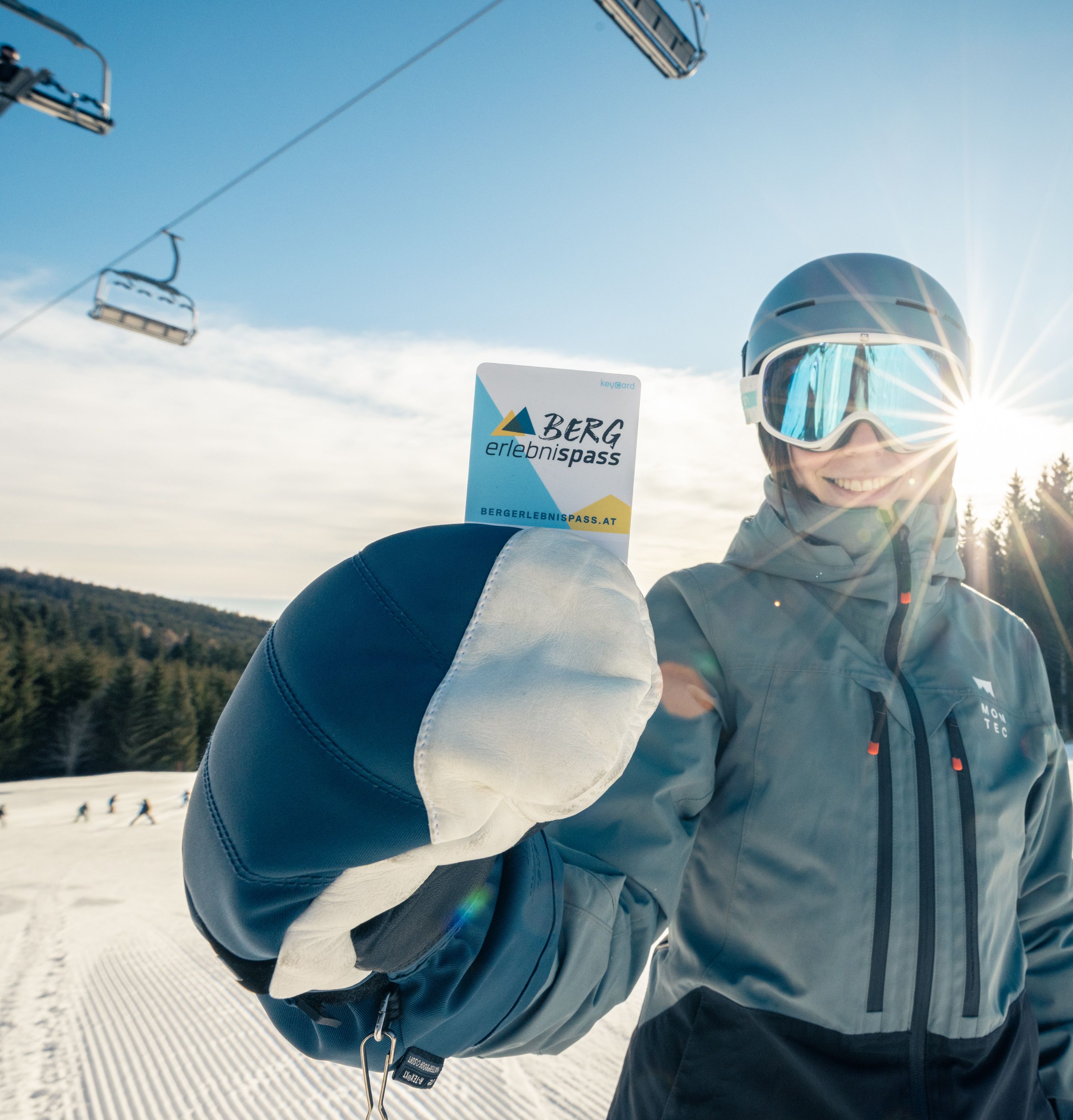 Frau hält Bergerlebnispass-Keycard in die Kamera.