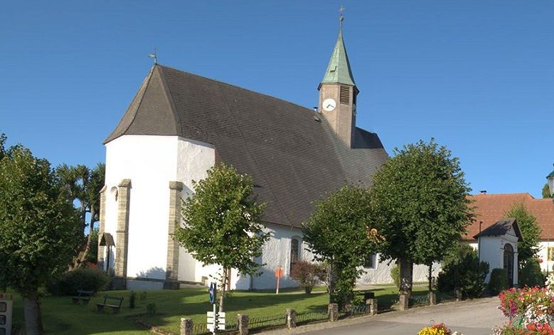 Wallfahrtskirche Maria Namen mit Turm und Bäumen im Vordergrund.