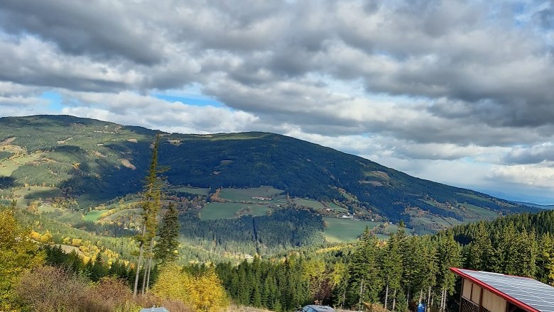 Panor&aacute;mak&eacute;p egy dombos t&aacute;jr&oacute;l, erdőkkel &eacute;s mezőkkel, felhős &eacute;gbolt alatt.