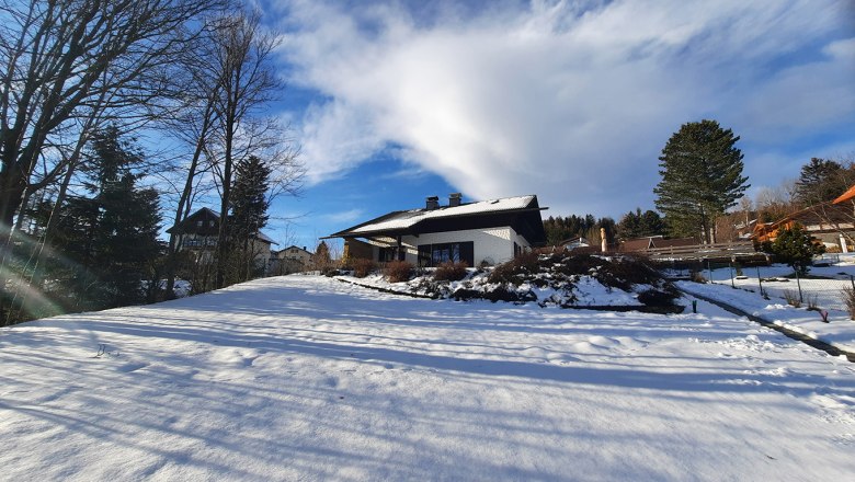 Belle Air Lodge im Winter, © Christoph Gierlinger Winterlandschaft mit einem Haus im Schnee, umgeben von Bäumen und blauem Himmel.
