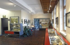 Innenansicht des Weltkulturerbe Infozentrums am Bahnhof Semmering mit Ausstellungsst&uuml;cken und Informationstafeln.