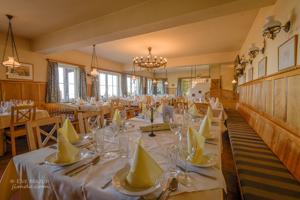 Elegantes Restaurant mit gedeckten Tischen und Kronleuchter.