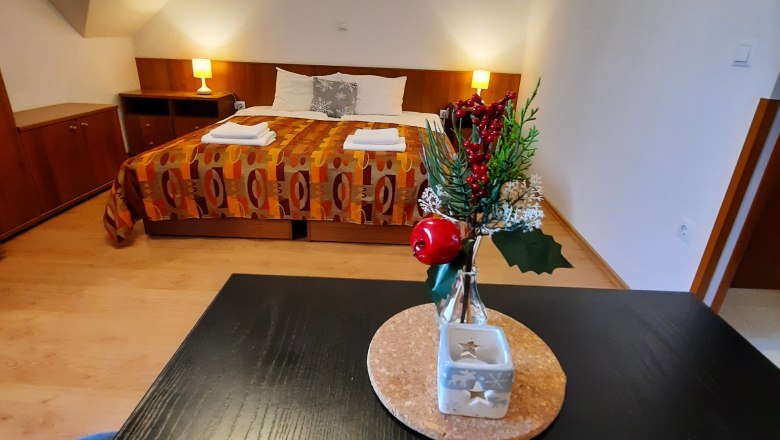 A cozy double room with a decorated table in the foreground and a bed in the background.