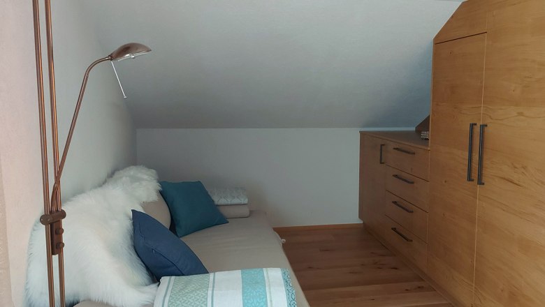 Double room on the upper floor with pull-out couch, wooden floor and wardrobe.