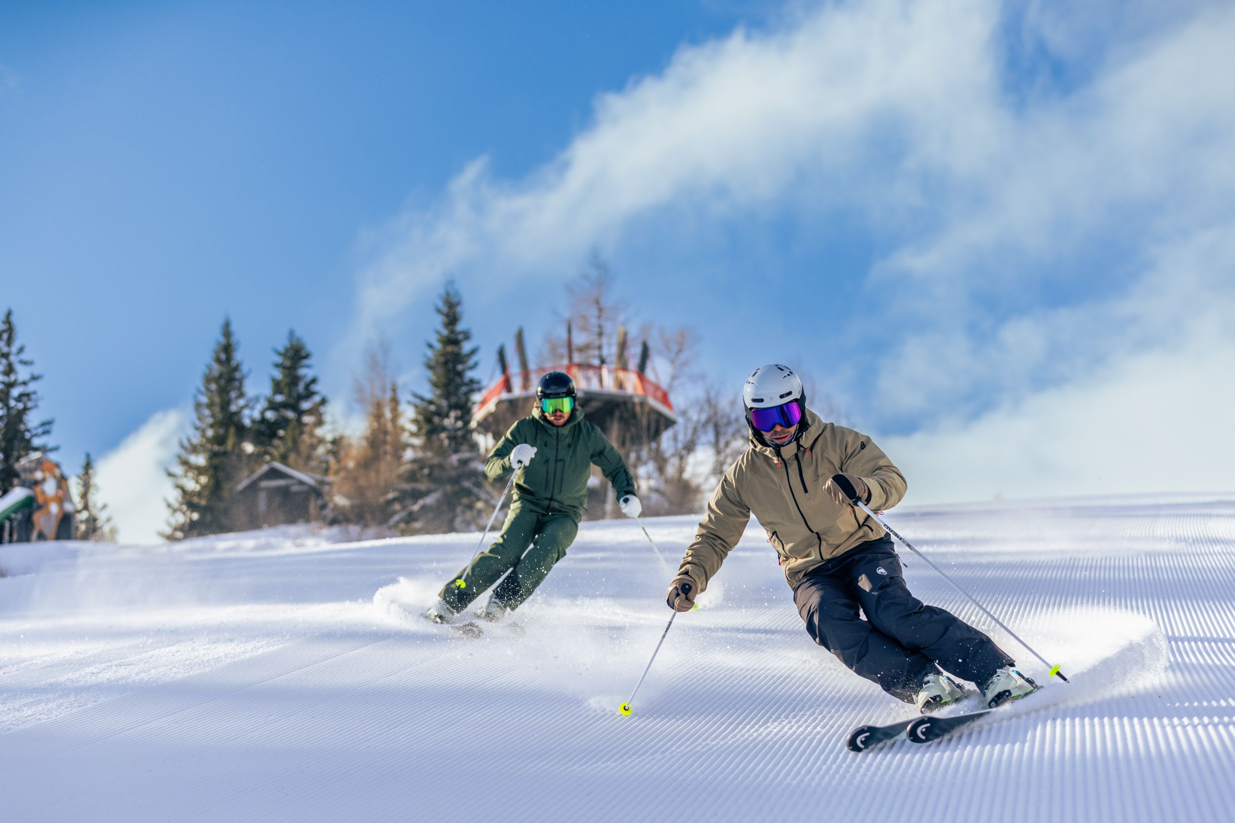 Zwei Skifahrer auf einer frisch präparierten Skipiste.