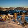 Alpengasthof Enzian in verschneiter Berglandschaft bei Sonnenuntergang.