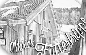 Schwarz-wei&szlig; Bild eines Holzhauses mit der Aufschrift 'Marios Futterkrippe'.