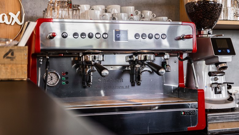 Professionelle Espressomaschine mit Tassen und Kaffeemühle.