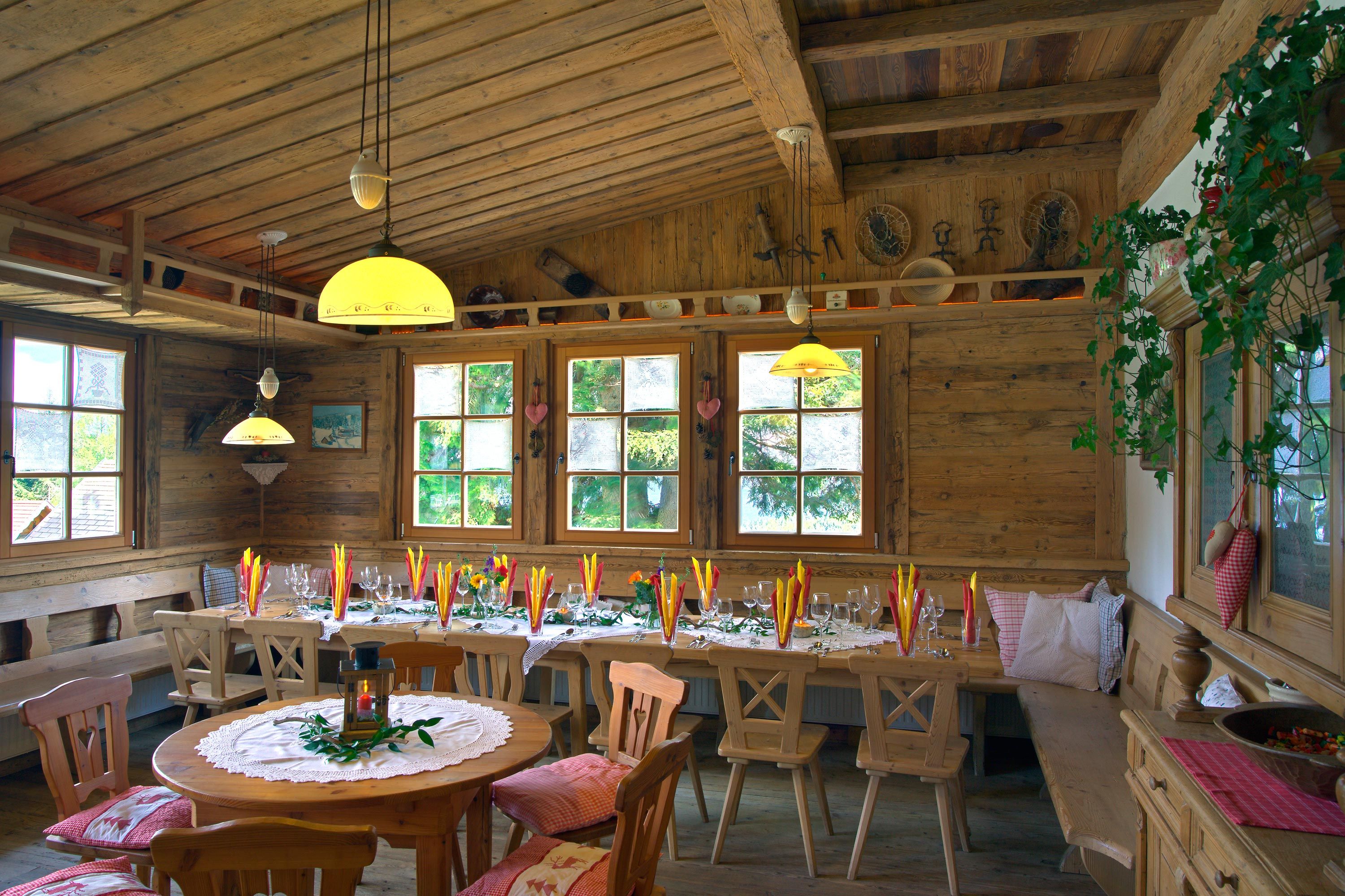 Gemütlicher Gastraum mit Holzmöbeln und dekoriertem Tisch.