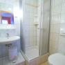 Small bathroom with shower, washbasin and toilet.