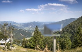 Blick von der Edelwei&szlig;h&uuml;tte auf den Schneeberg mit gr&uuml;nen W&auml;ldern und Bergen im Hintergrund.