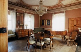 Elegantes Wohnzimmer im Hugo Wolf Haus mit antiken M&ouml;beln und Kronleuchter.