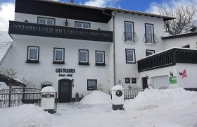 Winter view of a guest house covered in snow.