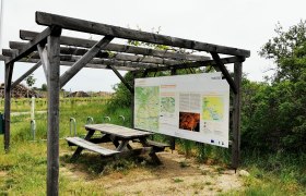 Radlerrastplatz mit Holztisch und Infotafel an der Weinstra&szlig;e im Weinviertel.