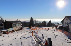 Skischule in Mönichkirchen mit Kindern auf der Piste und Sonnenschein.