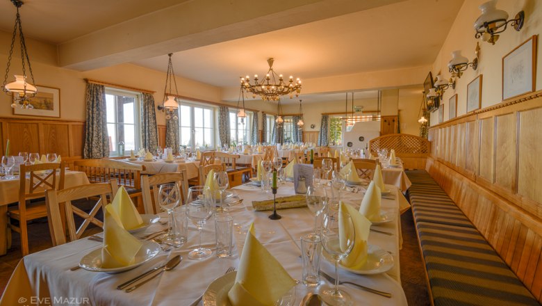 Elegantes Restaurant mit gedeckten Tischen und Kronleuchter.