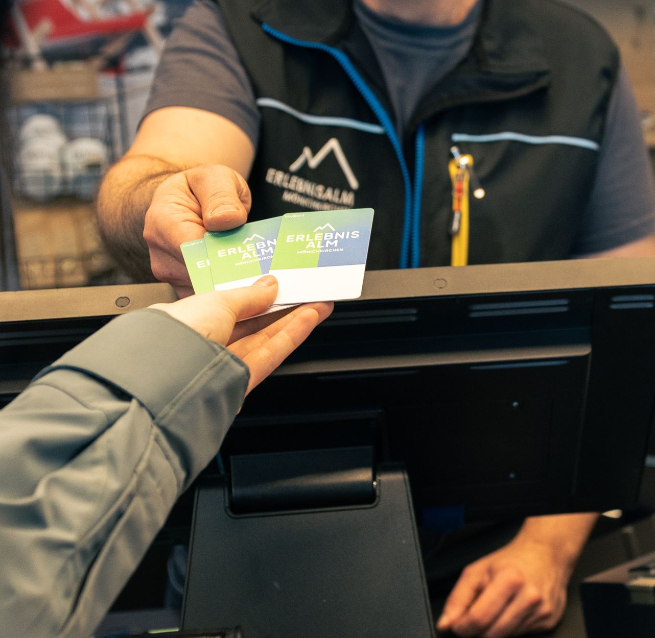 Ein Ticket wird von einer Mitarbeiterin oder einem Mitarbeiter an einen Gast übergeben. Die Übergabe findet im Eingangs- oder Kassenbereich statt.