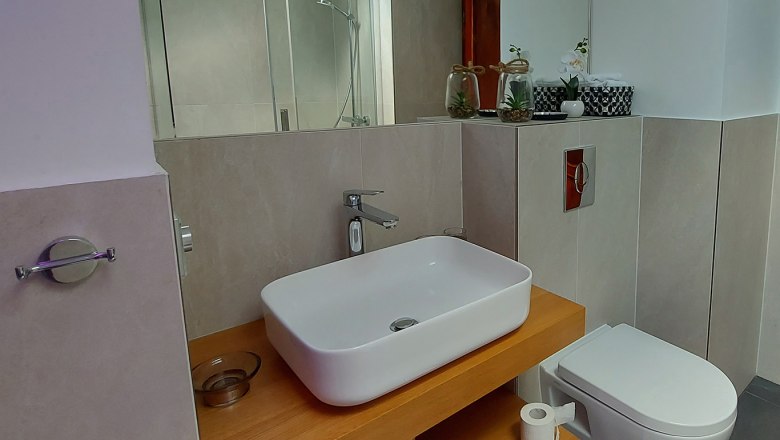Modern bathroom with washbasin, toilet and shower.