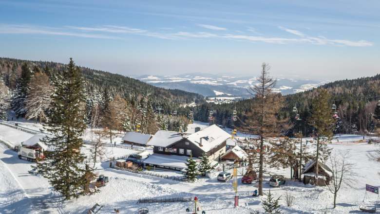 Mountain inn Mönichkirchner Schwaig, © Schischaukel-Mönichkirchen-Mariensee-GmbH-Fülöp Winter landscape with mountain inn and ski lift in Mönichkirchen.