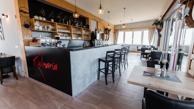 Belső n&eacute;zet egy modern &eacute;tteremről, b&aacute;rral &eacute;s &uuml;lősarokkal.